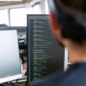 A male software engineer working on code in a modern office setting.