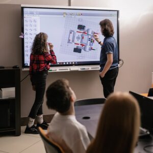 Teens engaged in robotics teamwork in a modern classroom setting.